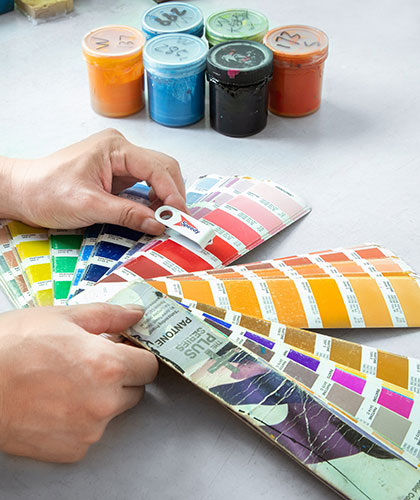 a worker is matching the color of a sample with the Panton card