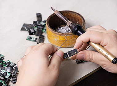 a worker is assembling chips on PCB panels